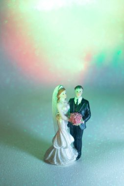 Düğün çifti pasta üstte plastik figürler smokin gece elbisesi, beyaz gelinlik peçesi.