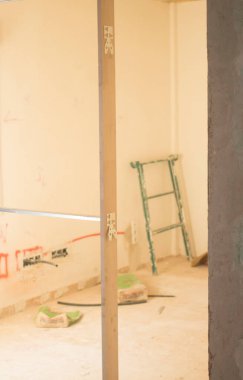 Bina yenileme çalışmaları, duvarları yenilemek için inşaat işçilerinin yaptığı yenilemeleri gösteriyor..