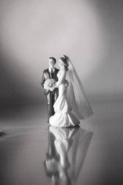 Düğün çifti pasta üstte plastik figürler smokin gece elbisesi, beyaz gelinlik peçesi.