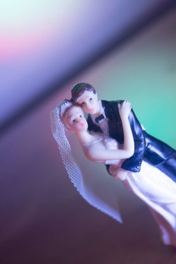 Düğün çifti pasta üstte plastik figürler smokin gece elbisesi, beyaz gelinlik peçesi.