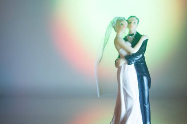 Düğün çifti pasta üstte plastik figürler smokin gece elbisesi, beyaz gelinlik peçesi.