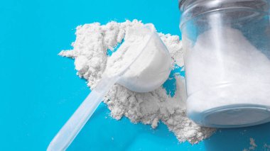 Spor ek, kreatin, hmb, bcaa, amino asit ya da vitamin mesure tozu ile. Spor beslenme kavramı. BCAA, l-karnitin, kreatin mavi arka planda