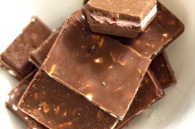 Beyaz arka plan üzerinde üstten görünüm kırık koyu çikolata parçaları küçük bardaklar