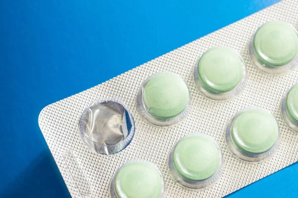 packaging with green pills on a blue background