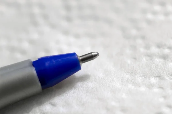 Tiro molhado de uma caneta esferográfica azul em um fundo branco — Fotografia de Stock