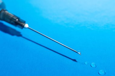 Tıbbi şırınga iğne üzerinde mavi arka plan, makro çekim