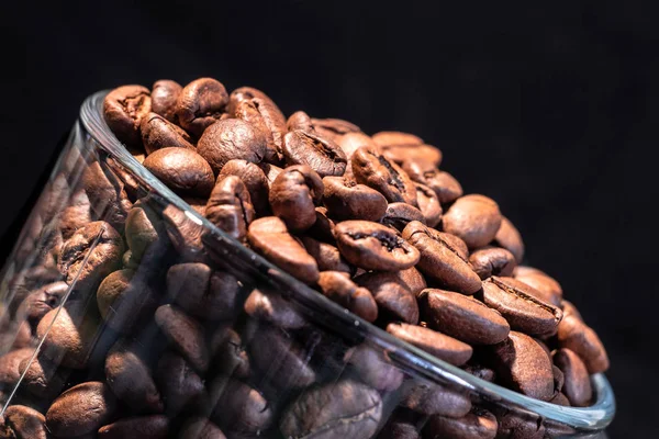 Mug transparan di dalam dengan biji kopi, semua dalam nada coklat, dalam kunci rendah, close up, tembakan makro — Stok Foto