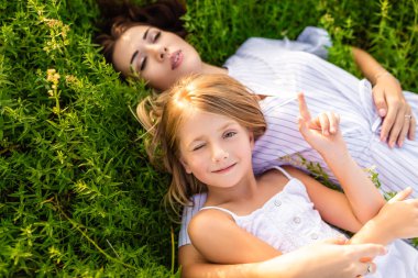 mutlu anne ve kızı çiçekli çayırda yalan sırasında rahatlatıcı