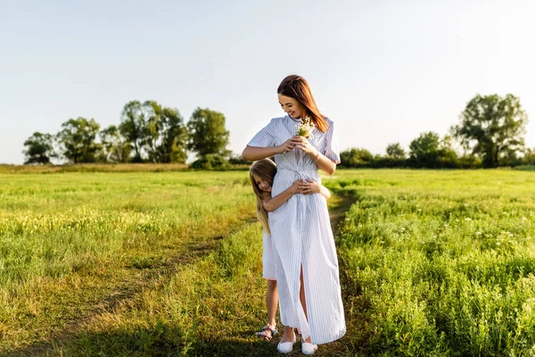 buket ve yeşil çayır sunset Bulvarında kucaklayan kızı ile güzel annem