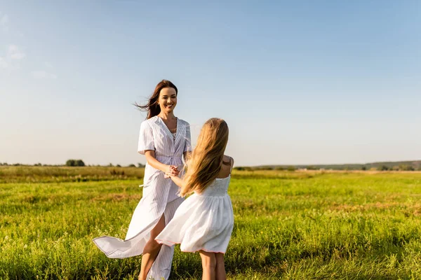 美丽快乐的母亲和女儿在绿色的草地上玩耍 — 图库照片
