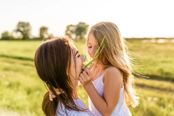 母亲和女儿的特写画像在绿色草甸一起乐趣 图库图片