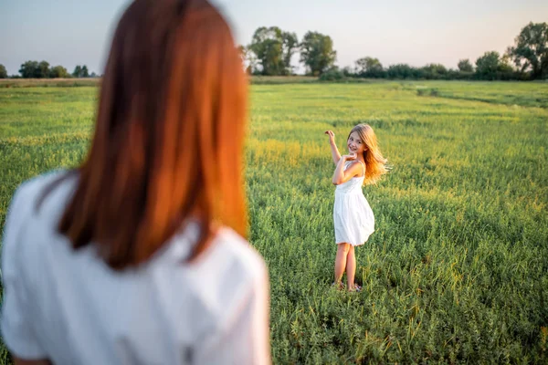 Madre e hija feliz pasar tiempo juntos en el prado verde - foto de stock