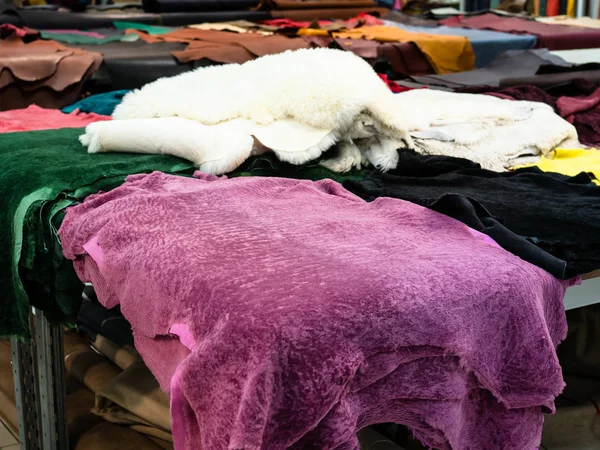 pink colored sheep skins on table in leather workshop