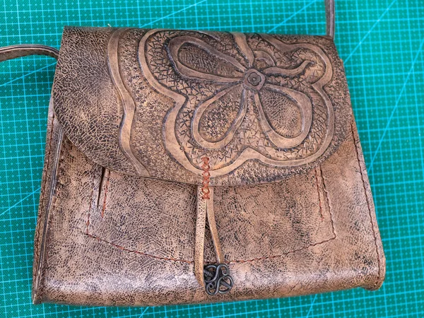 workshop of making the carved leather bag - view of the wet handbag polished by wax
