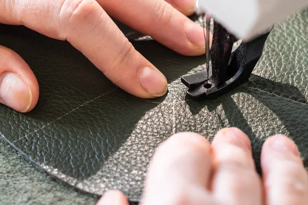 workshop of making the leather bag for jewelry - craftsman sews pockets of pouch on sewing machine