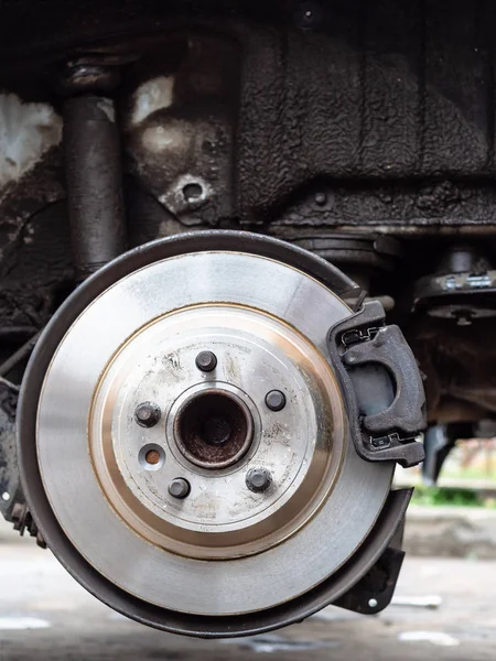 front view of new brake disc on old vehicle close up