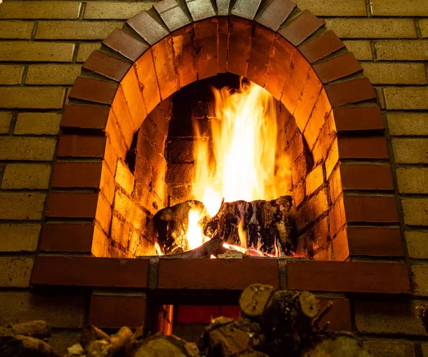 bottom view of brick fireplace with fire in rural house