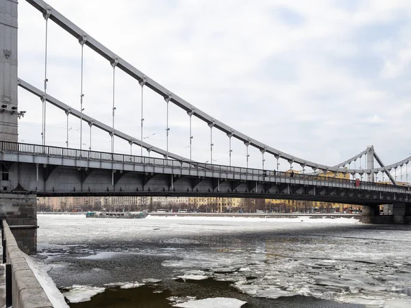 view of Krymsky (Crimean) Bridge over frozen Moskva River in Moscow city in overcast winter day. Krymsky Bridge is the only suspension bridge in all of Moscow