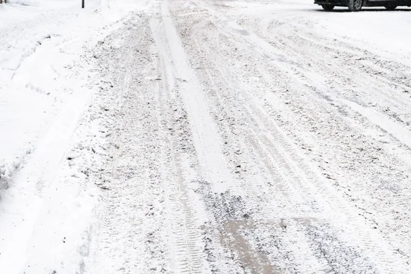 not cleaned snow-covered slippery urban road after snow blizzard in snowy winter day