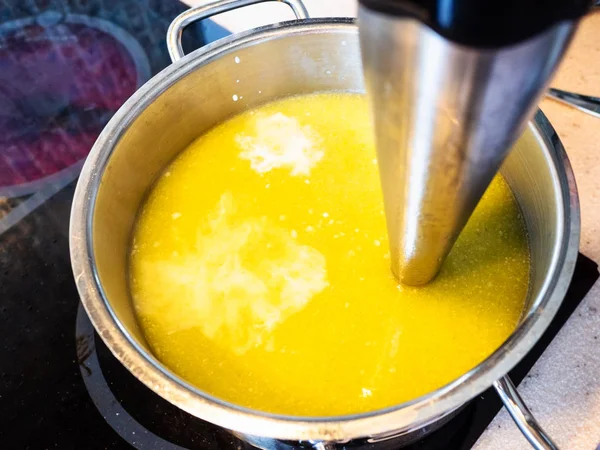 cooking vegetable soup puree with butter in pan