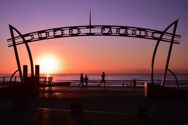 Sign of Surfers Paradise at sunrise time with people walking