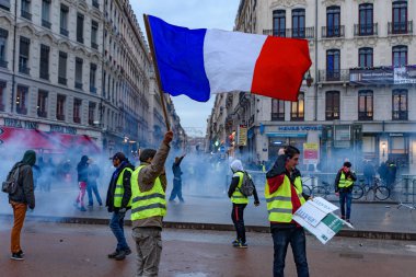 Sarı yelek (Gilets Jaunes), yakıt vergisi, hükümet ve Fransa Cumhurbaşkanı Macron karşı protesto. Bir protestocu sahnede Fransız bayrağı sallıyordum. Lyon, Fransa. 