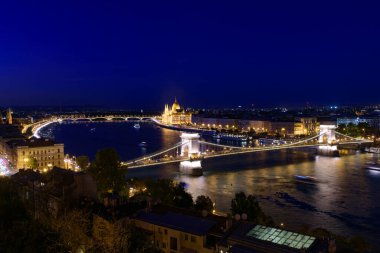 Macaristan Parlamento Binası, Szechenyi Zinciri Köprüsü ve Macaristan 'ın Budapeşte kentindeki Tuna Nehri' nin gece manzarası