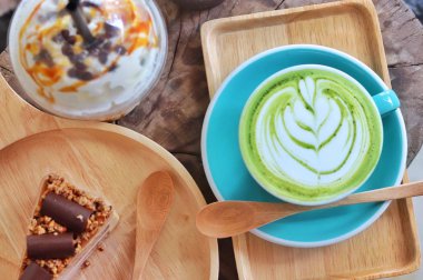 ahşap masa üzerinde çikolata pasta ve yeşil çay kahve