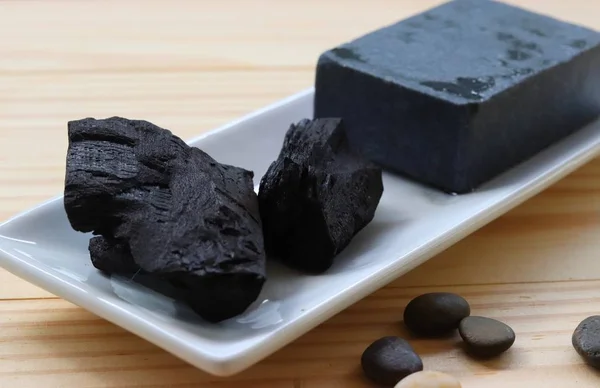 carbon and bamboo charcoal soap on wood background