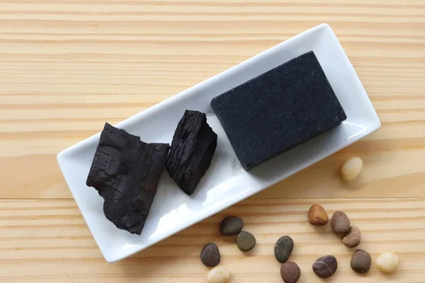 carbon and bamboo charcoal soap on wood background