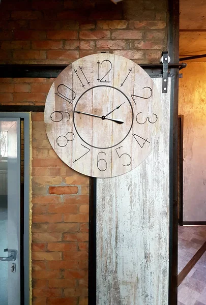 Large round clocks hang in the interior in a loft style