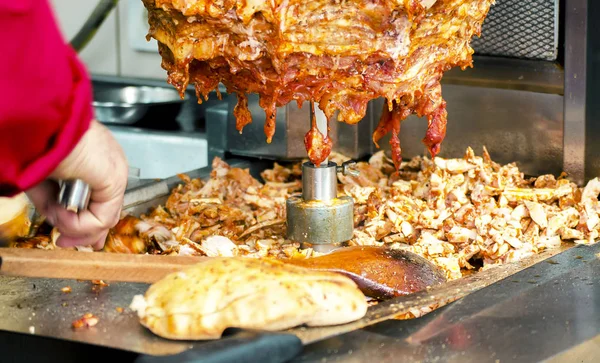 Bir sokak yemek dükkanında geleneksel Türk yemekleri Döner Kebap kesme bir şef. İstanbul'da sokak yemekleri.