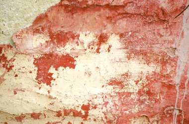 Eski evin duvarının yakın çekim bir parçası. Pembe arka plan. Beton bir yüzey üzerinde sıva soyma. Boyadaki çatlaklar.