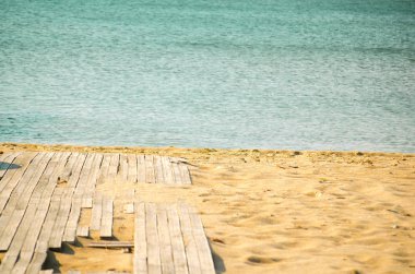 Tropikal sahildeki ahşap iskele ve mavi gökyüzü yaz arkaplanı. Tatil arka planı, kopyalama alanı. Seçici odak resmi.