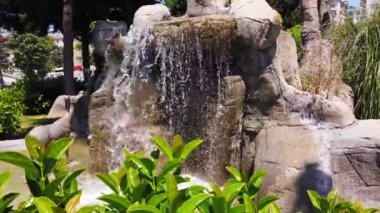 Şehir parkında dekoratif çeşme. Su yapay taşların, kayaların üzerinden akar..