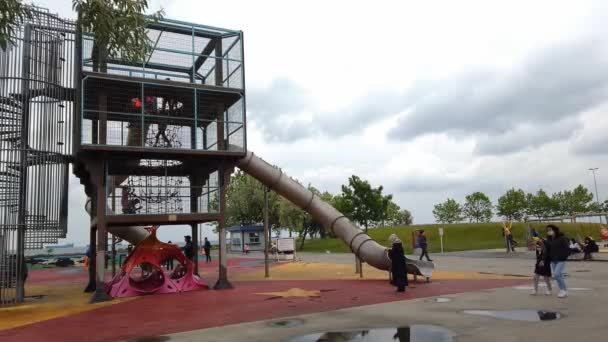 Chmury, pochmurny dzień. nowoczesny plac zabaw dla dzieci na świeżym powietrzu na promenadzie. — Wideo stockowe