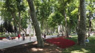 Sultanahmet bölgesindeki Gulhane Parkı 'nda insanlar yürüyor, rahatlıyor, çimlere oturuyor. İstanbul.