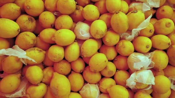 Beautiful juicy bright yellow lemons on blue shop or bazaar counter. Close-up. — Stock Video
