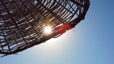 Güneş, güneş ışınları, güneş ışığı hasır plaj şemsiyesinde parlıyor güneşten.