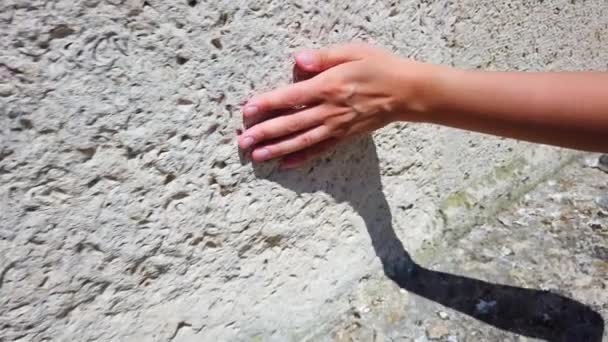 Mano femminile toccare dura superficie ruvida di roccia. rallentatore. — Video Stock