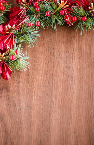 Yeşil ladin dalları. Kahverengi ahşap arka plan. Beyaz, kırmızı, çok renkli Noel oyuncakları. Ahşap ve seramiklerden yapılmış Noel ağacı süslemeleri. Şenlikli eğlence konsepti. Tebrik arkaplanı. 