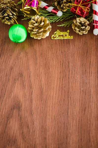 Green spruce branches. Brown wooden background. White, red, multi-colored Christmas toys. Decorations for Christmas tree made of wood and ceramics. Festive fun concept. Congratulatory backdrop.