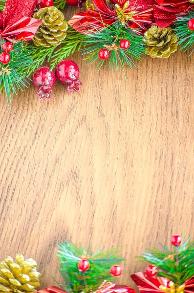 Yeşil ladin dalları. Kahverengi ahşap arka plan. Beyaz, kırmızı, çok renkli Noel oyuncakları. Ahşap ve seramiklerden yapılmış Noel ağacı süslemeleri. Şenlikli eğlence konsepti. Tebrik arkaplanı. 