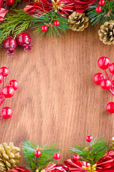 Yeşil ladin dalları. Kahverengi ahşap arka plan. Beyaz, kırmızı, çok renkli Noel oyuncakları. Ahşap ve seramiklerden yapılmış Noel ağacı süslemeleri. Şenlikli eğlence konsepti. Tebrik arkaplanı. 