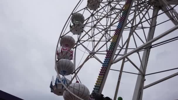 Grande roue en métal gris argenté dans un parc d'attractions. Vue du bas. Jour nuageux. — Video