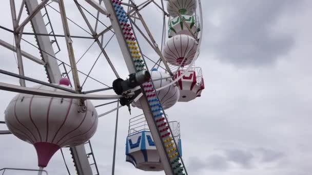 Grande roue en métal gris argenté dans un parc d'attractions. Vue du bas. Jour nuageux. — Video