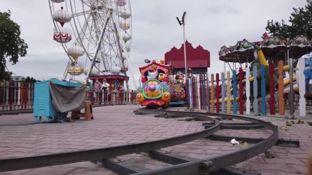 Heldere, kleurrijke, kindertreinrit op metalen rails. pretpark voor kinderen — Stockvideo