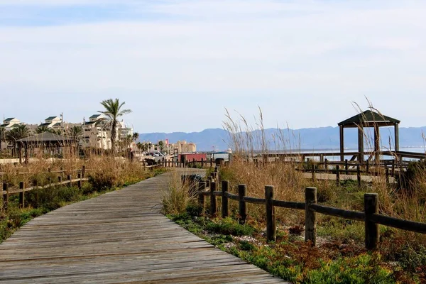 Sahilde gazebo ve arka planda dağlar ile ahşap yolu