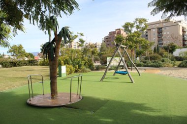 Salıncak ve carousel çimenlerin üzerinde oyun alanında