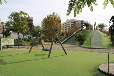 Salıncak ve carousel çimenlerin üzerinde oyun alanında